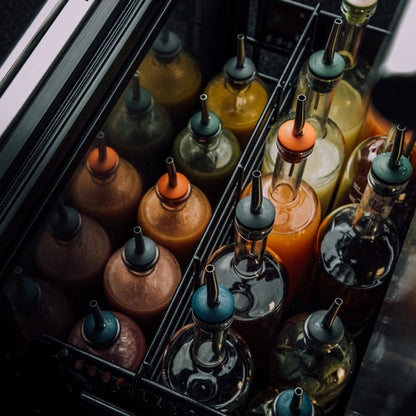 Pour spouts of various colors on bar bottles for juice
