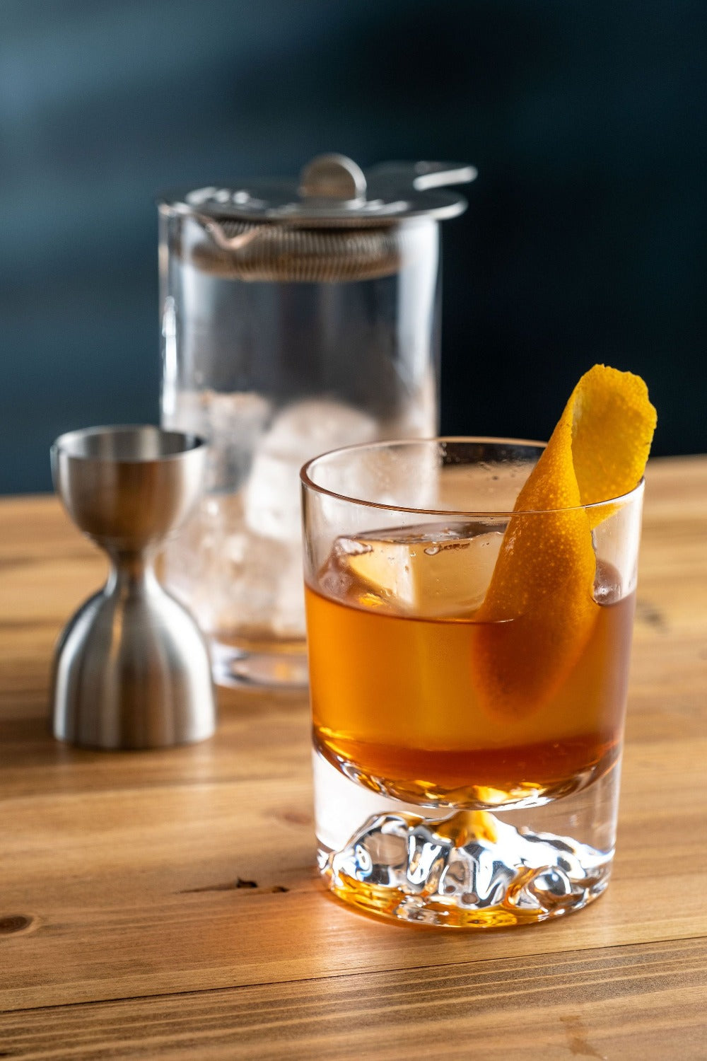 Old Fashioned in an Amehla Co. Mountain rocks old fashioned glass with honeycomb mixing glass, jigger, and strainer in background. Photo by Jordan Hughes of High Proof Preacher