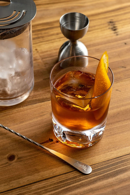 Old Fashioned in an Amehla Co. Mountain Rocks Old Fashioned Glass surrounded by honeycomb mixing glass, strainer, jigger, and barspoon. Photo by Jordan Hughes of High Proof Preacher.