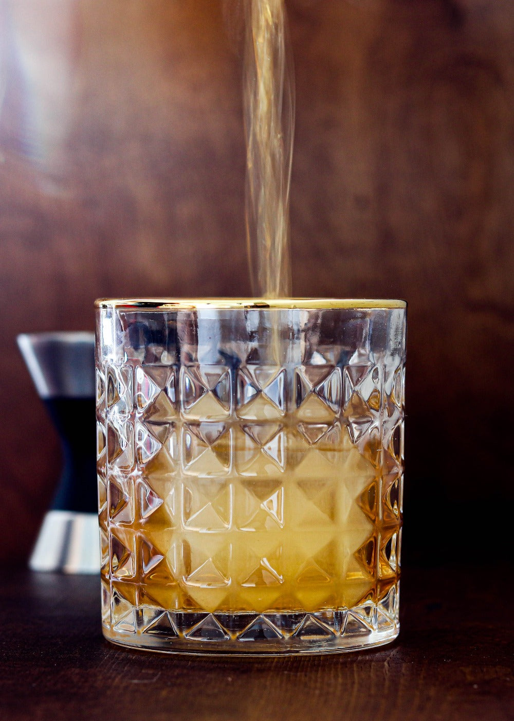 Old Fashioned being poured into an Amehla Co. Gold Rimmed Old Fashioned Rocks Glass