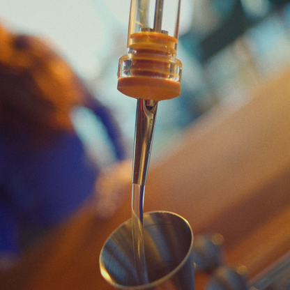 Speed pourer pouring liquid into a jigger at a bar