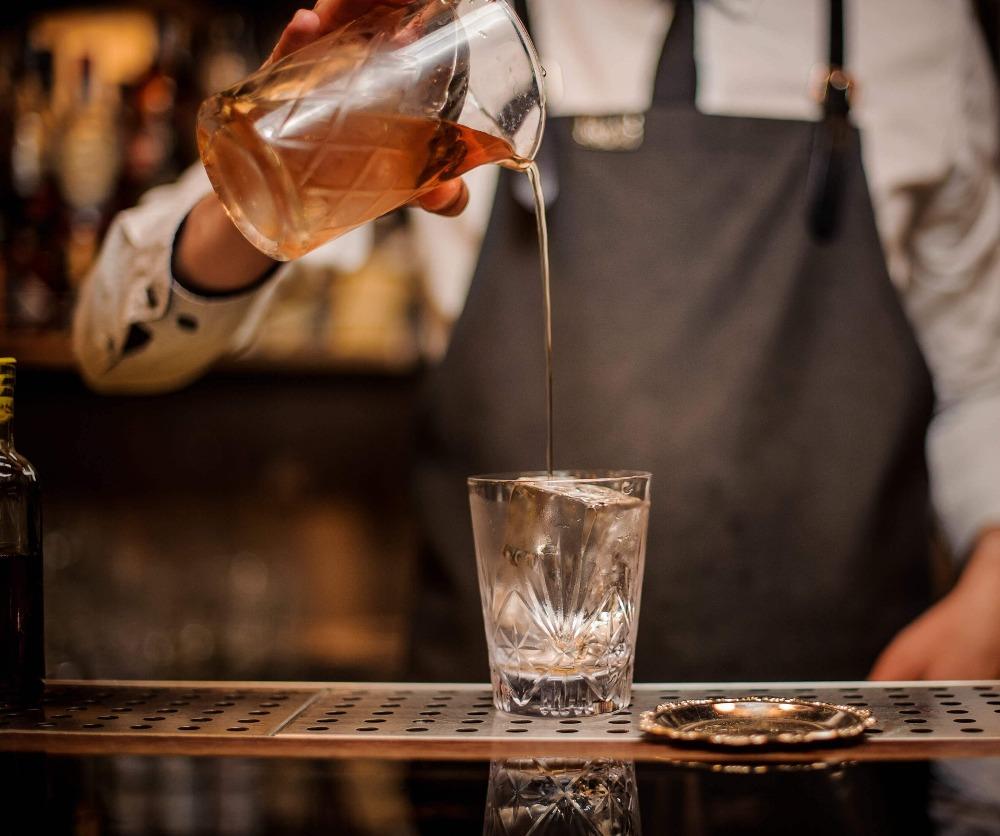 Original yarai cocktail mixing glass from amehla co. pouring cocktail into an old fashioned rocks glass