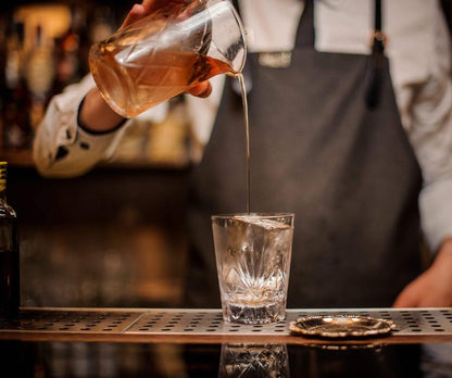 Original yarai cocktail mixing glass from amehla co. pouring cocktail into an old fashioned rocks glass